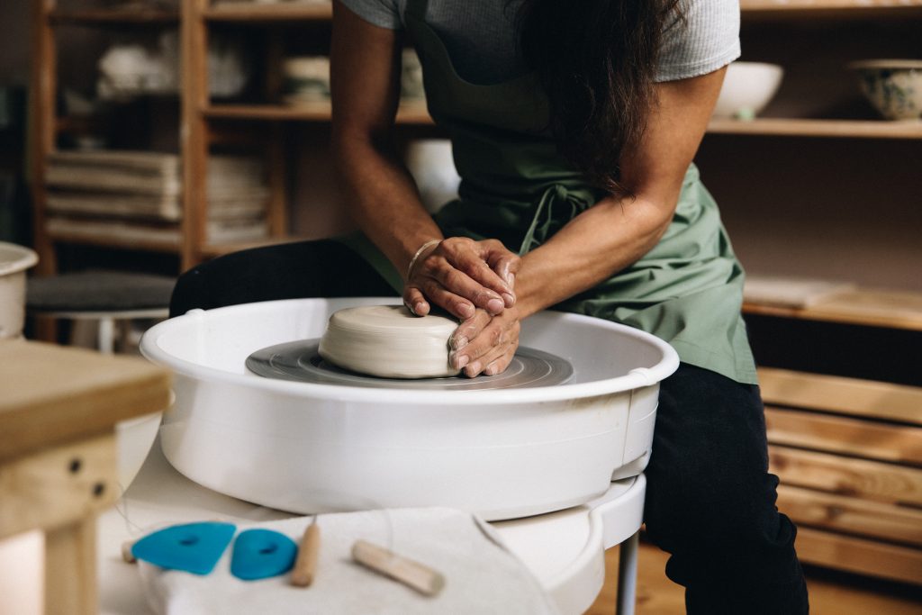 Hände zentrieren Ton an der Töpferscheibe im Verenics Studio Wien – Eintragung Warteliste für Töpferkurse.